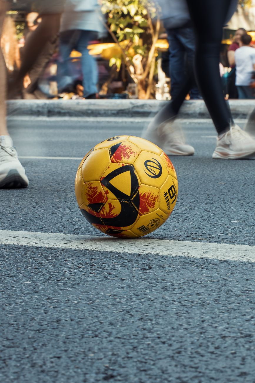 Ballon de football sur le bitume en pleine rue, ambiance blokecore et streetwear urbain