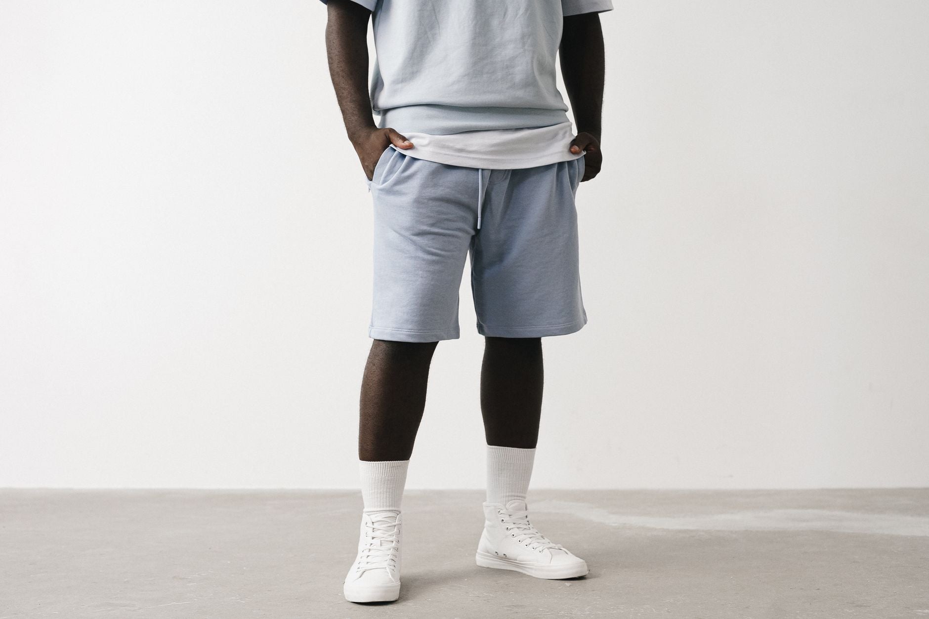 Homme en bermuda streetwear bleu clair et t-shirt oversize coordonné, look urbain épuré