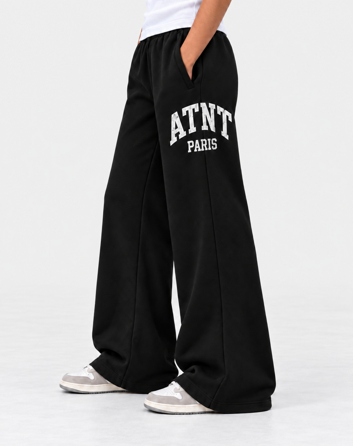 Jogging femme ATNT PARIS noir, coupe et bas, fond gris neutre