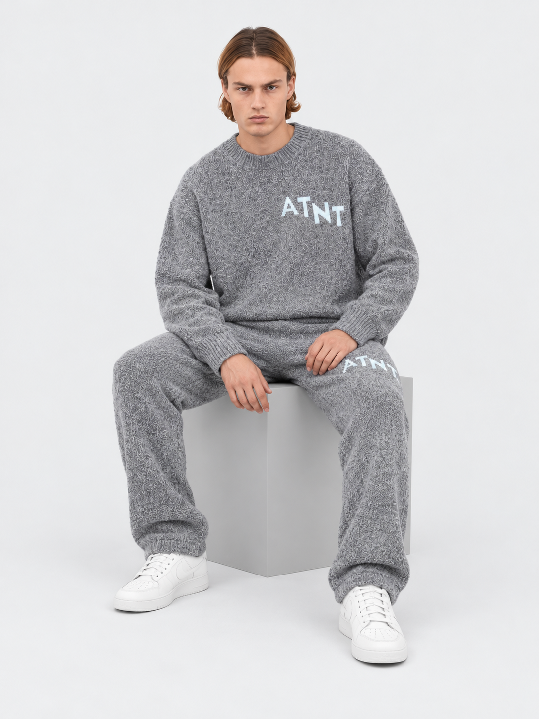 ATNT Tracksuits studio : Pull Oversize Gris Effet Cachemire, vue assise sur fond gris clair