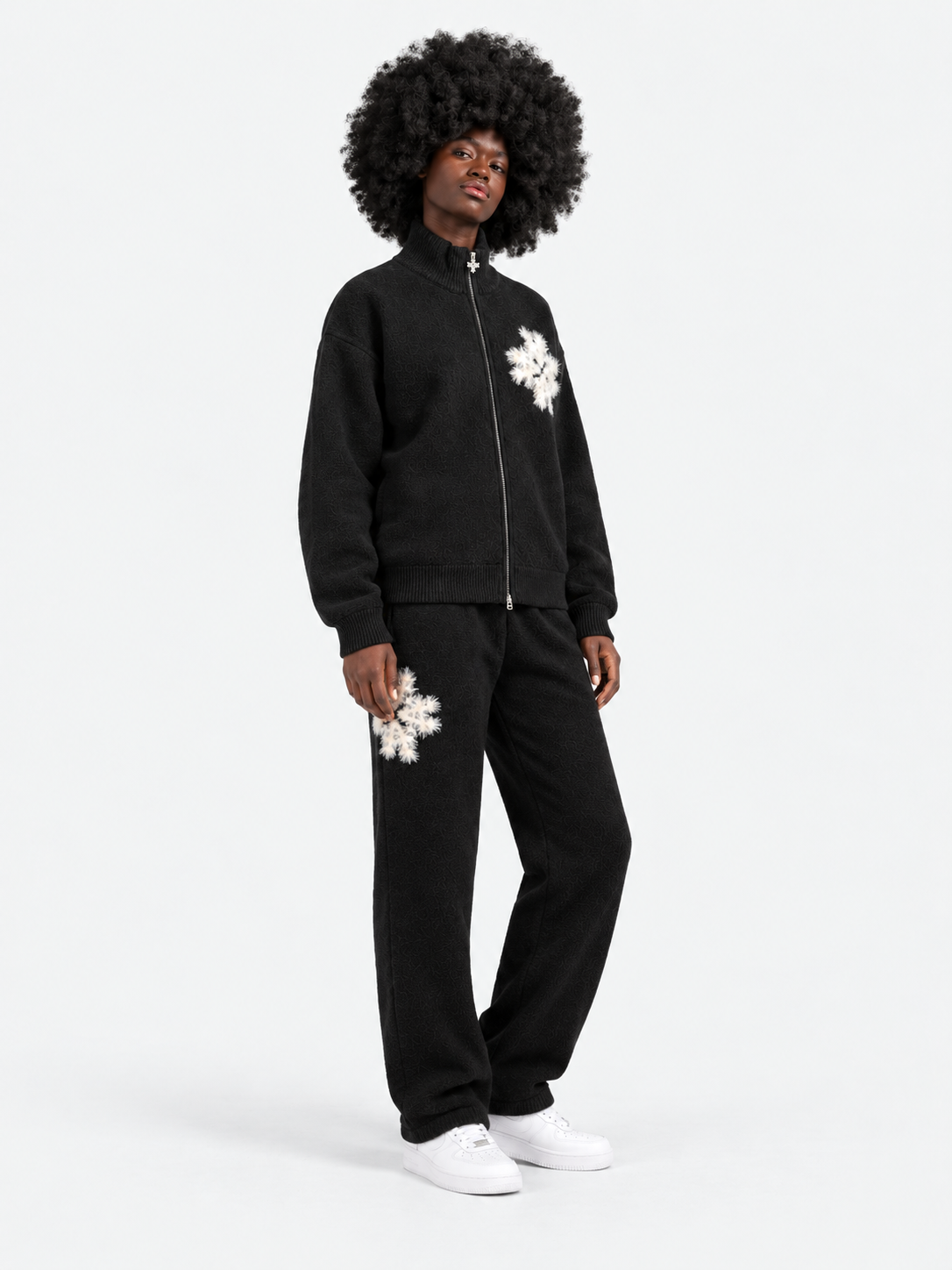ATNT Tracksuits studio : Pantalon de jogging en maille fluffy monogramme signature noir, vue de trois quarts sur fond gris clair