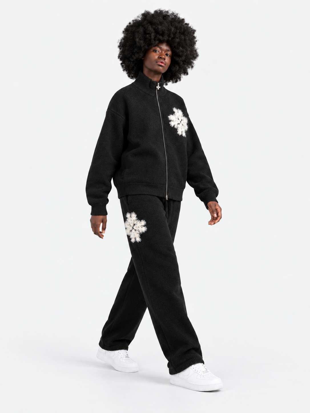ATNT Tracksuits studio : Pantalon de jogging en maille fluffy monogramme signature noir, vue en mouvement sur fond gris clair