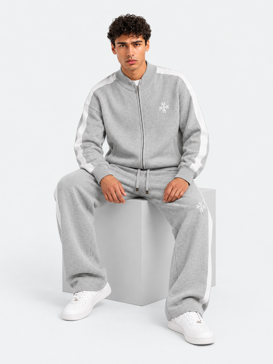 ATNT Tracksuits studio : Pantalon Knitted Gris Signature rayures latérales, vue assise sur fond gris clair