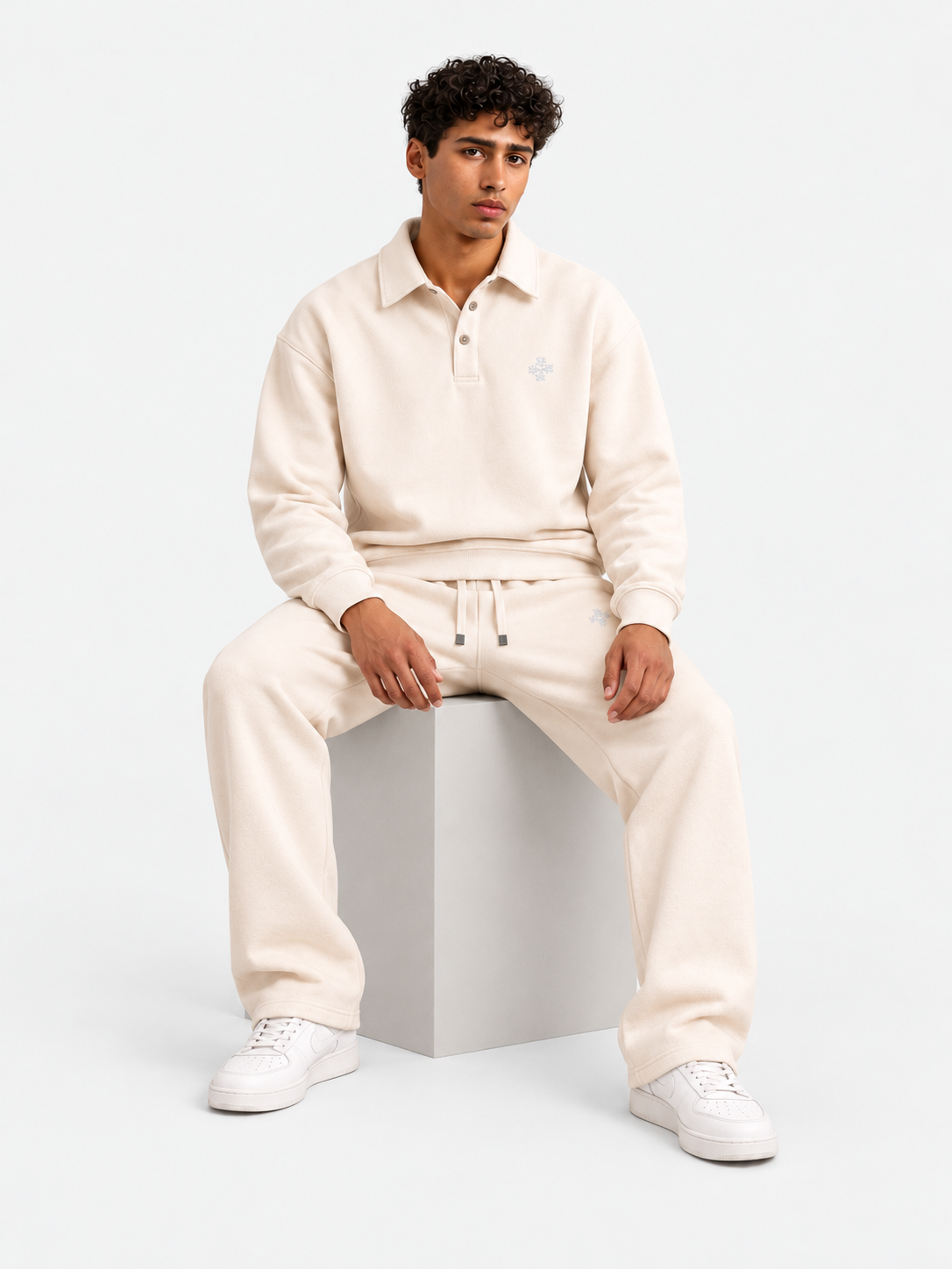 ATNT Tracksuits studio : Jogging Megeve Off White, vue assise sur fond gris clair