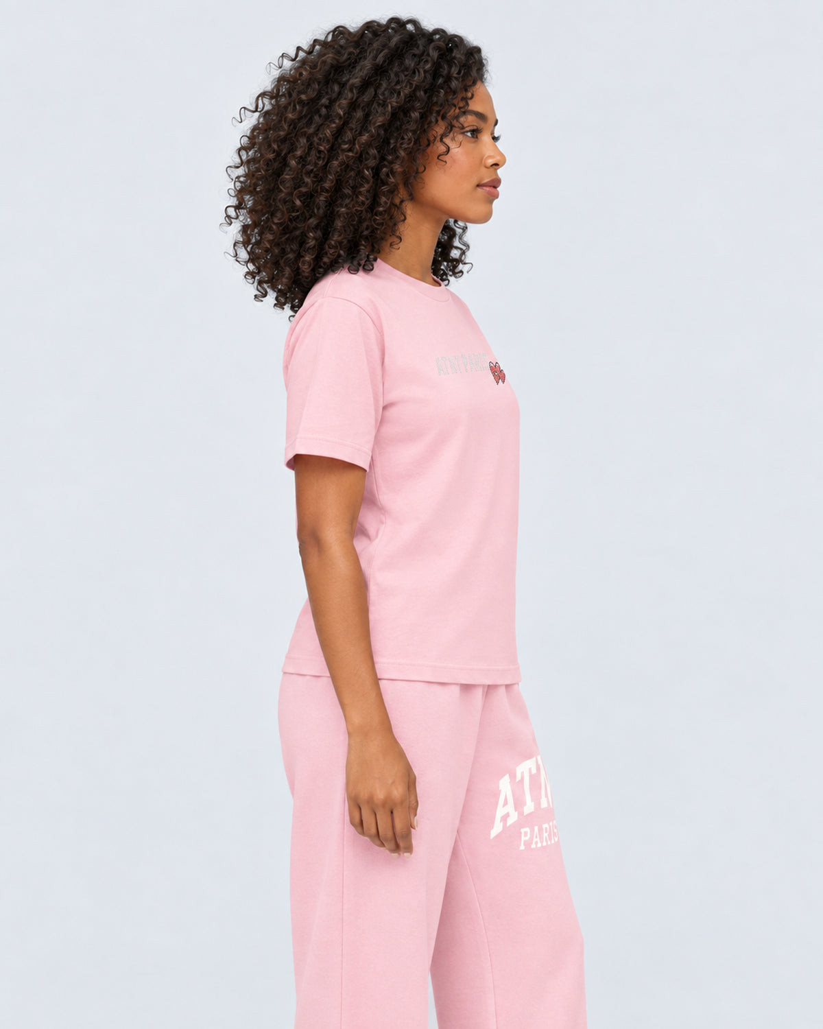 T-shirt Love Heart Strass rose clair ATNT PARIS — porté de profil, plan rapproché — studio gris clair, mannequin femme