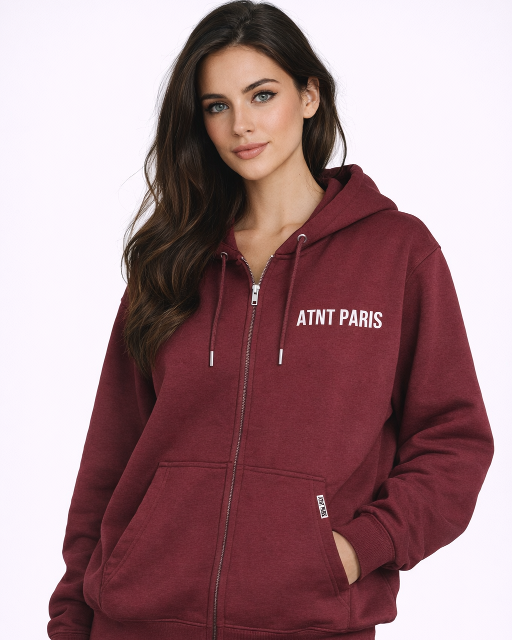 Gilet à capuche zippé bordeaux ATNT Paris porté par mannequin femme, coupe oversize, logo blanc poitrine, photo studio fond blanc