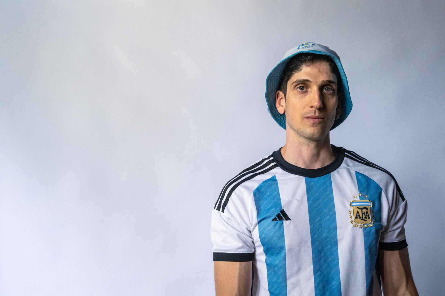 Jeune homme portant un maillot de foot en mode streetwear avec un look urbain complet et décontracté