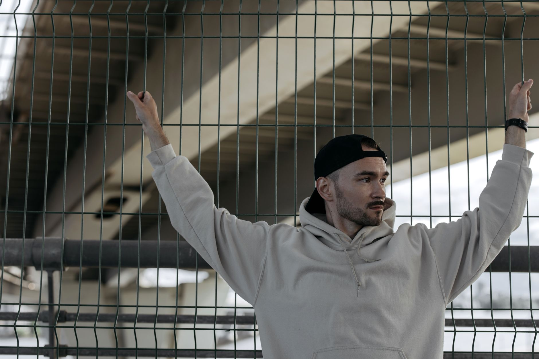 jeune homme en sweat à capuche oversize style Y2K urbain sous un pont