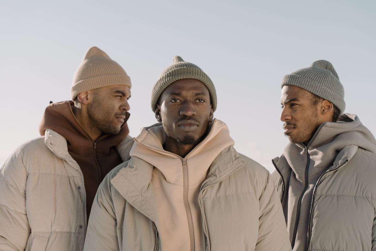 Trois hommes portant des bonnets streetwear avec des doudounes hivernales aux tons neutres