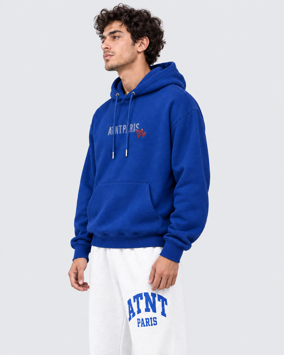 Sweat Capuche Bleu Roi Love heart Strass ATNT PARIS — Pack studio naturel — mannequin homme, vue latérale rapprochée — fond gris clair