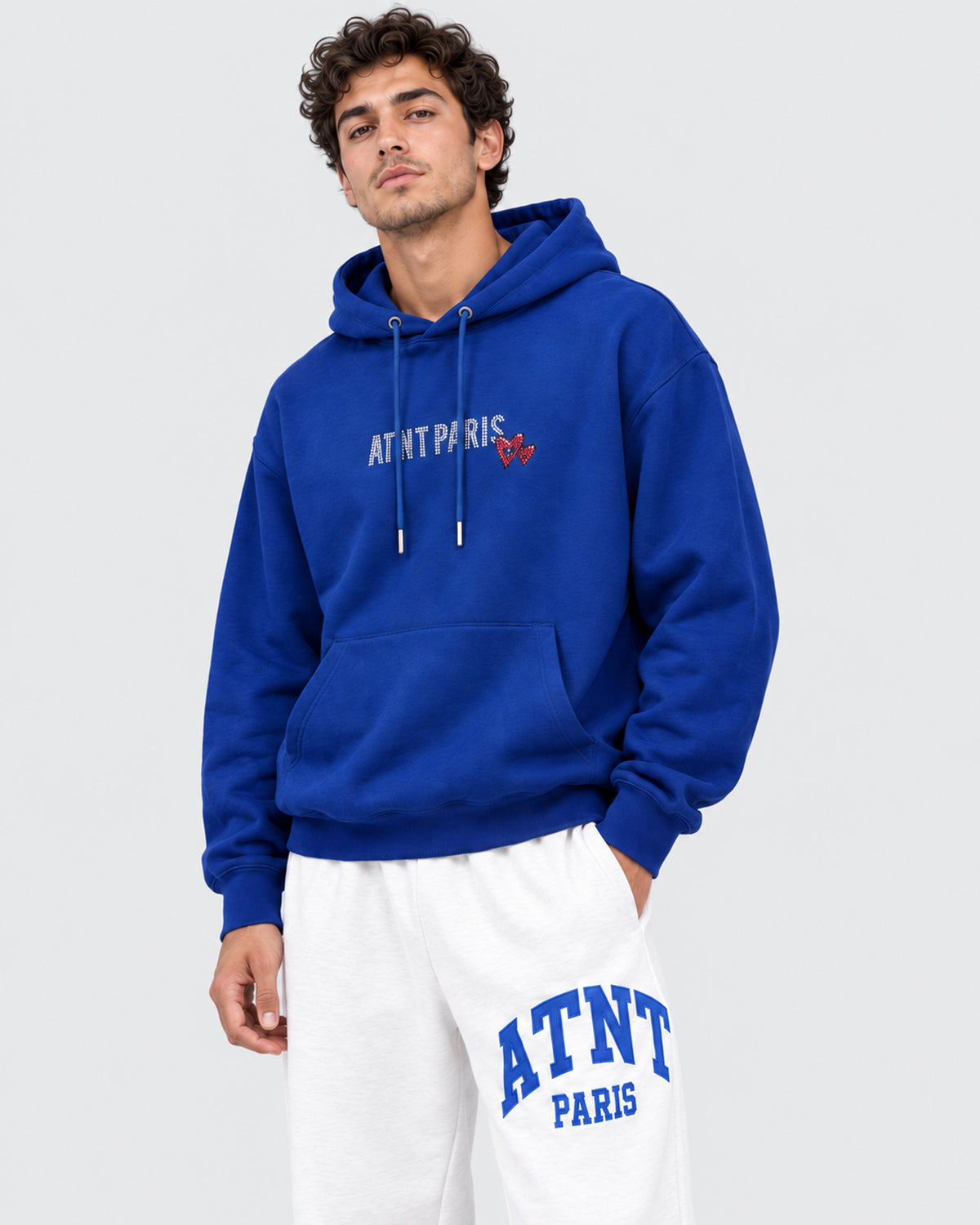 Sweat Capuche Bleu Roi Love heart Strass ATNT PARIS — Pack studio naturel — mannequin homme, vue de trois-quarts rapprochée — fond gris clair