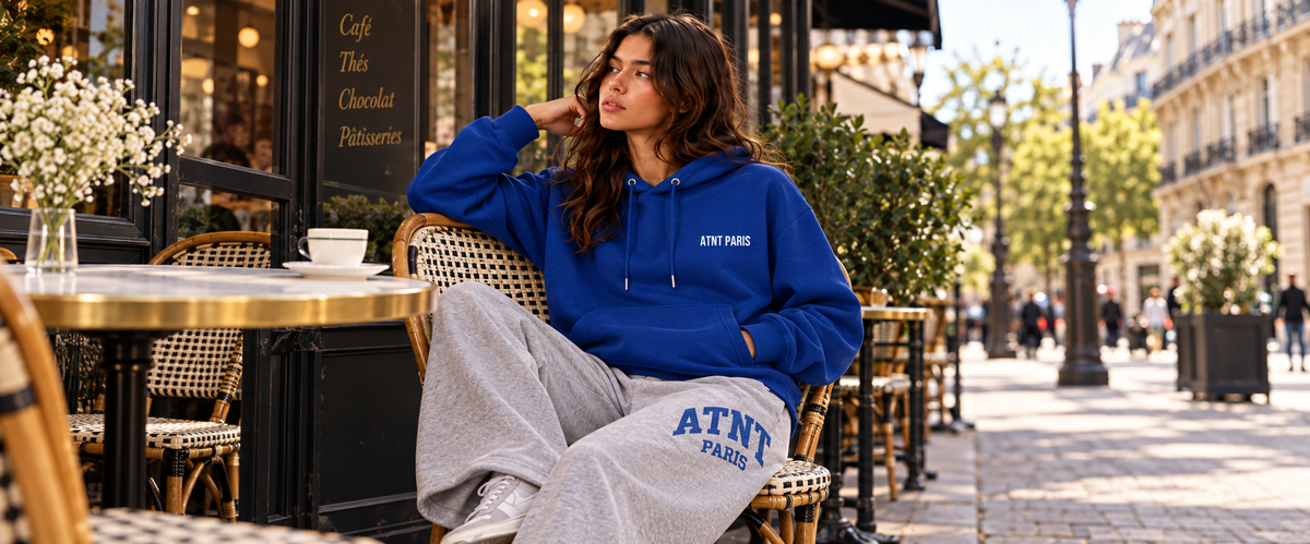 Sweat Capuche Bleu –  Essentials porté dans une ambiance lifestyle ATNT PARIS