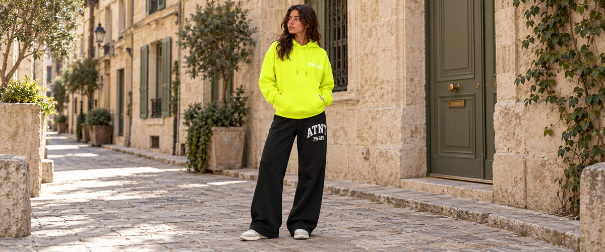 Sweat Capuche Jaune Fluo  –  Essentials porté dans une ambiance lifestyle ATNT PARIS