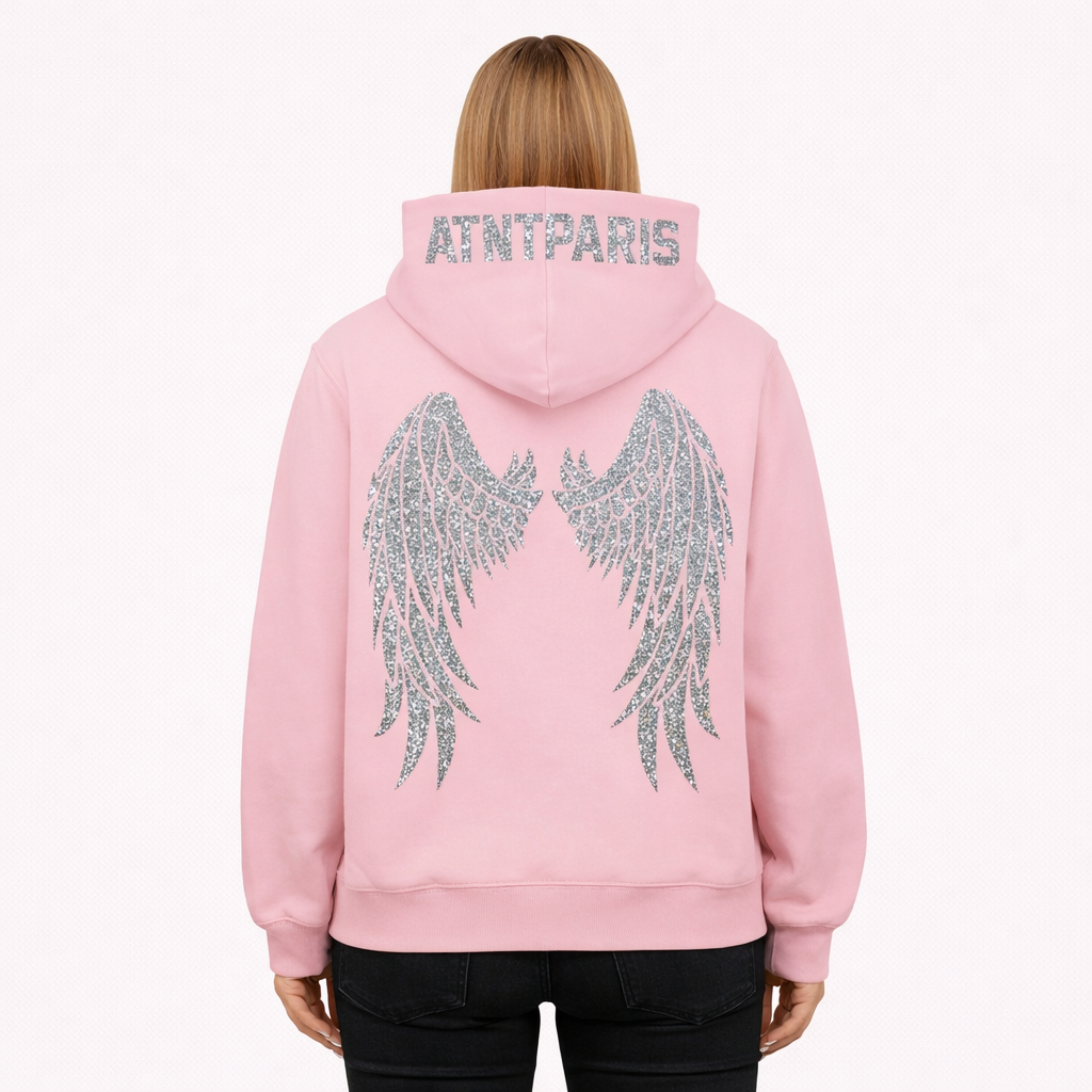 Mannequin femme portant un sweat à capuche rose ATNT Paris, vue de dos, ailes en strass brillants et logo ATNT Paris en strass sur la capuche, style streetwear premium