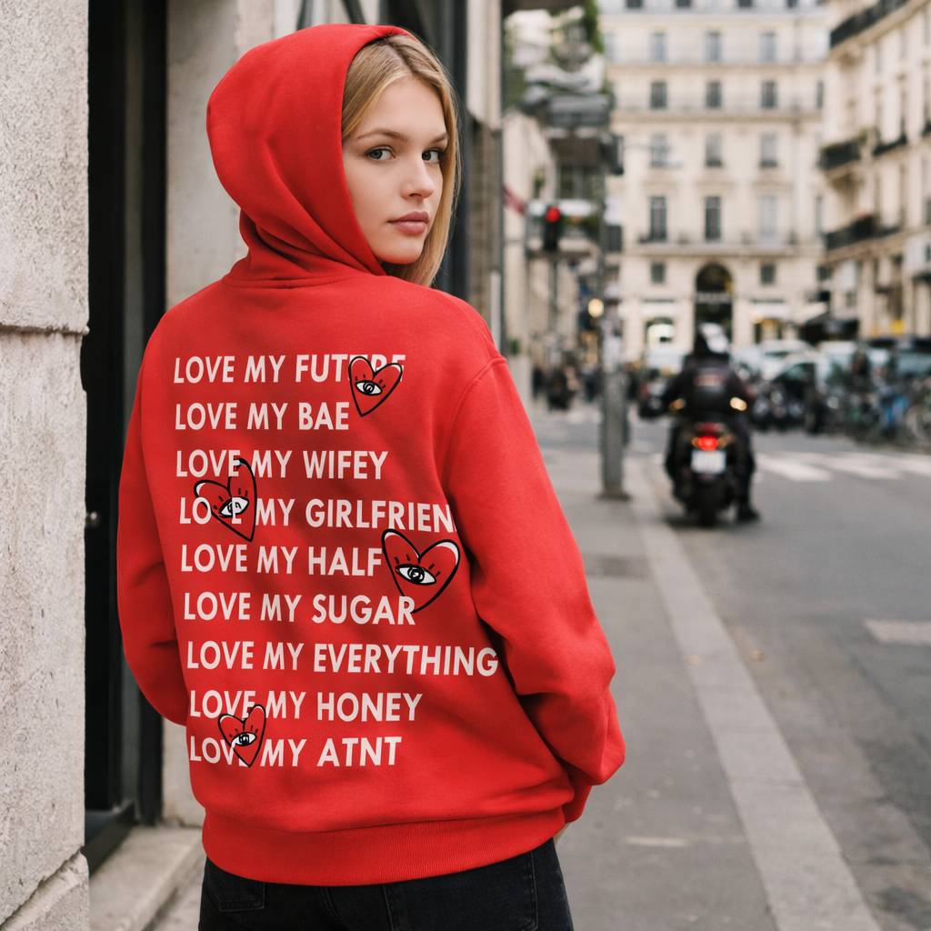 Sweat à capuche rouge ATNT Paris porté par mannequin femme en milieu urbain, vue de dos, imprimé « Love heart » avec cœurs graphiques, style streetwear