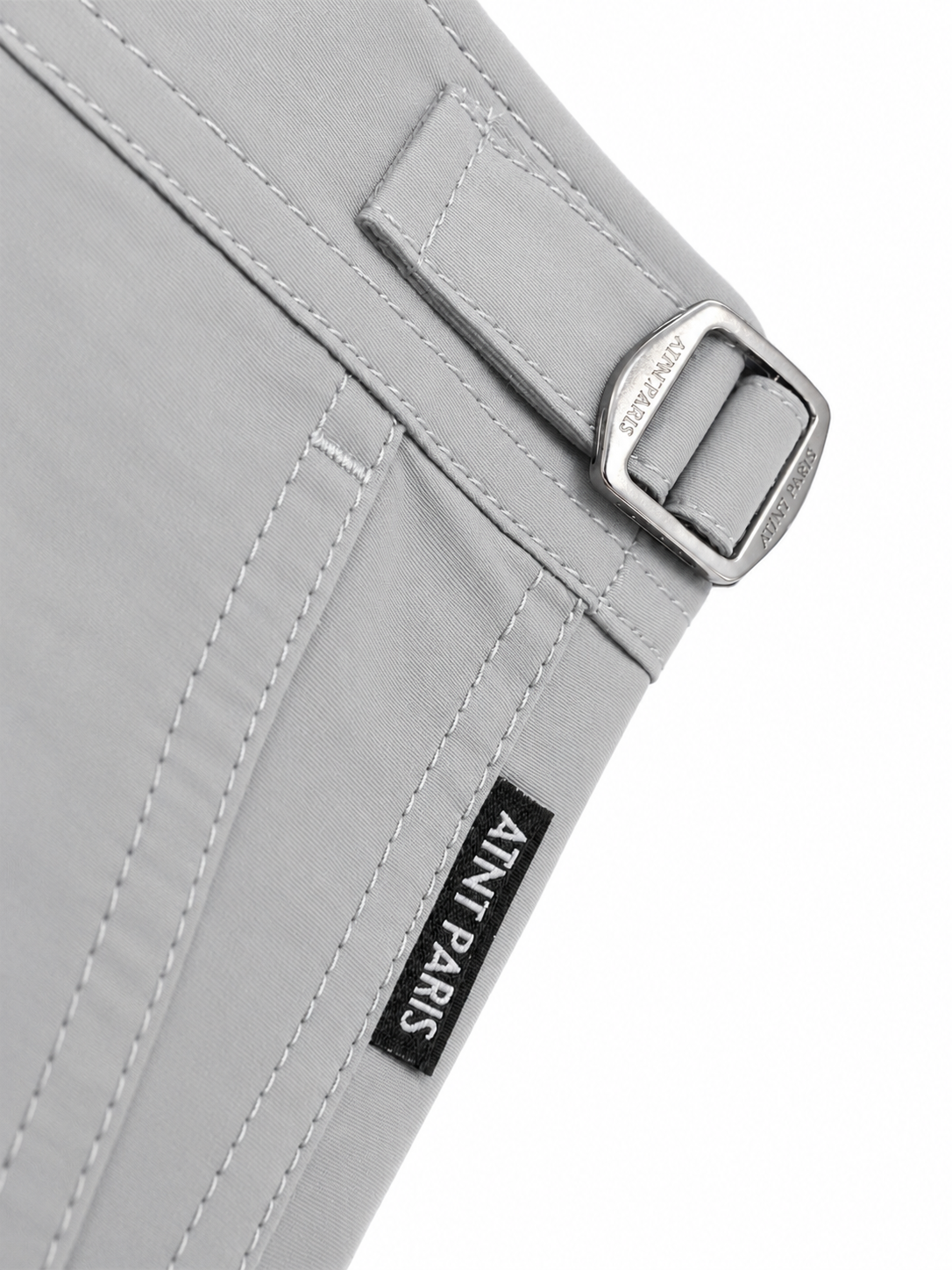 Short de bain riviera gris perle ATNT PARIS, détail de la patte de réglage et de l’étiquette.